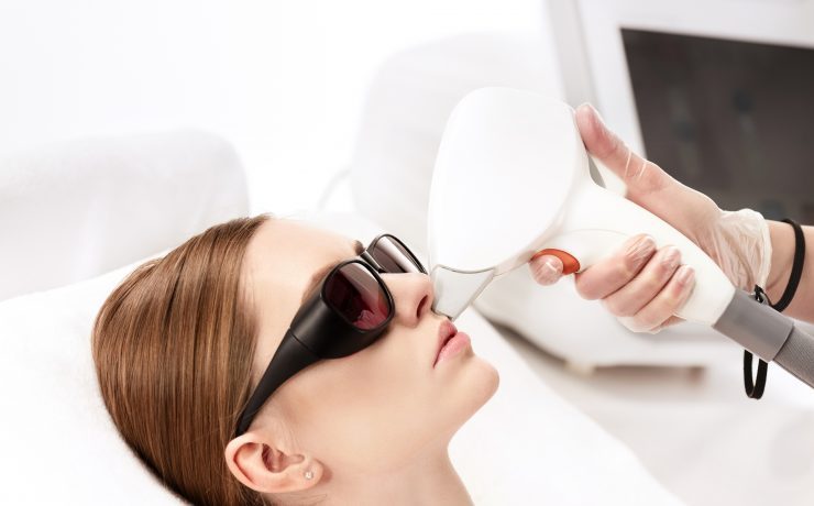 young woman receiving laser hair removal epilation on face isolated on white. laser skin care concept
